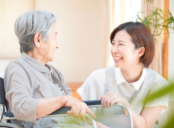看護師と高齢者が笑顔で会話している様子